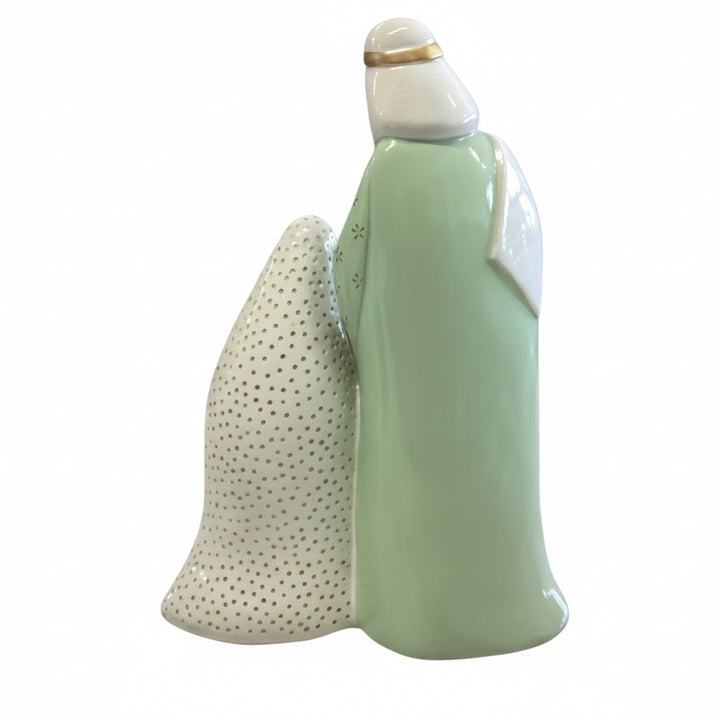 Pastel Nativity figurine with a mint green robed figure and a textured white form with gold dots.