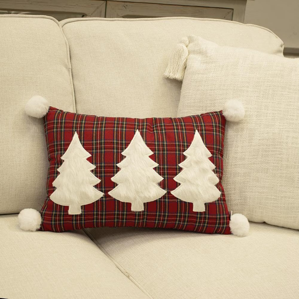 Rectangular red plaid White Spruce Plaid Throw Pillow with three white applique trees and four corner pom-poms.