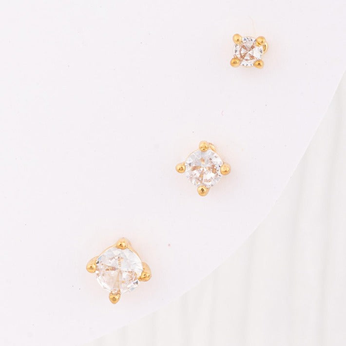Esme Luxe Earrings: three clear gemstone studs in gold settings, each a different size. Available in S, M, L.