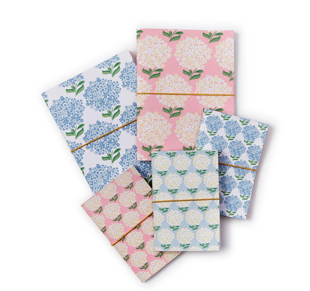 Hydrangea Soft Cover Notebooks in blue, pink, or white floral, gold elastic closure, unlined recycled cotton pages. Sizes: A5, A6.