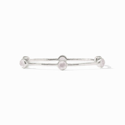 Silver bangle with five round pale pink gemstones on a textured band. Available in small, medium, and large sizes.