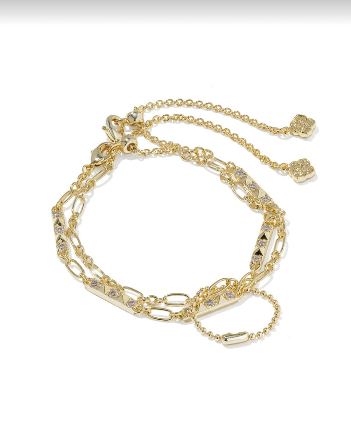 Set of two delicate gold bracelets with layered chains, decorative links, and white CZ charms. Available sizes: S, M, L.