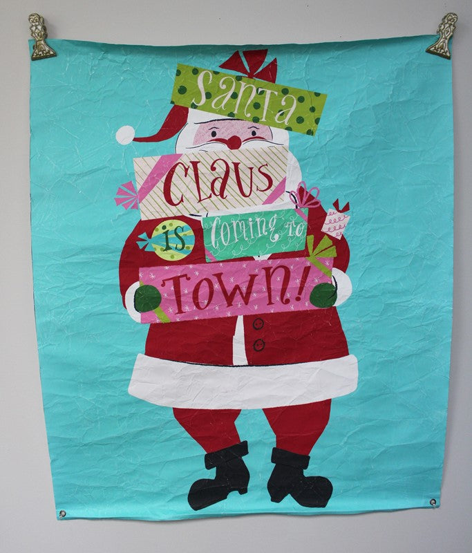 Paper Art Santa Claus holding presents with “Santa Claus is coming to town!” text.