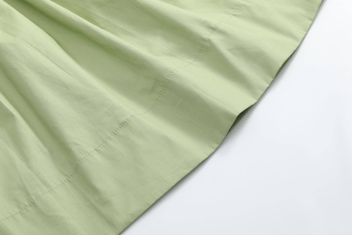 Pistachio green fabric with a visible seam, from the Mallard Duck Smocked Bishop Dress available in size 12-18M.
