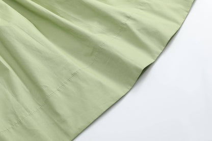 Close-up of pistachio green fabric with visible stitching and gentle folds, from the Mallard Duck Smocked Bishop Dress available in size 4T.