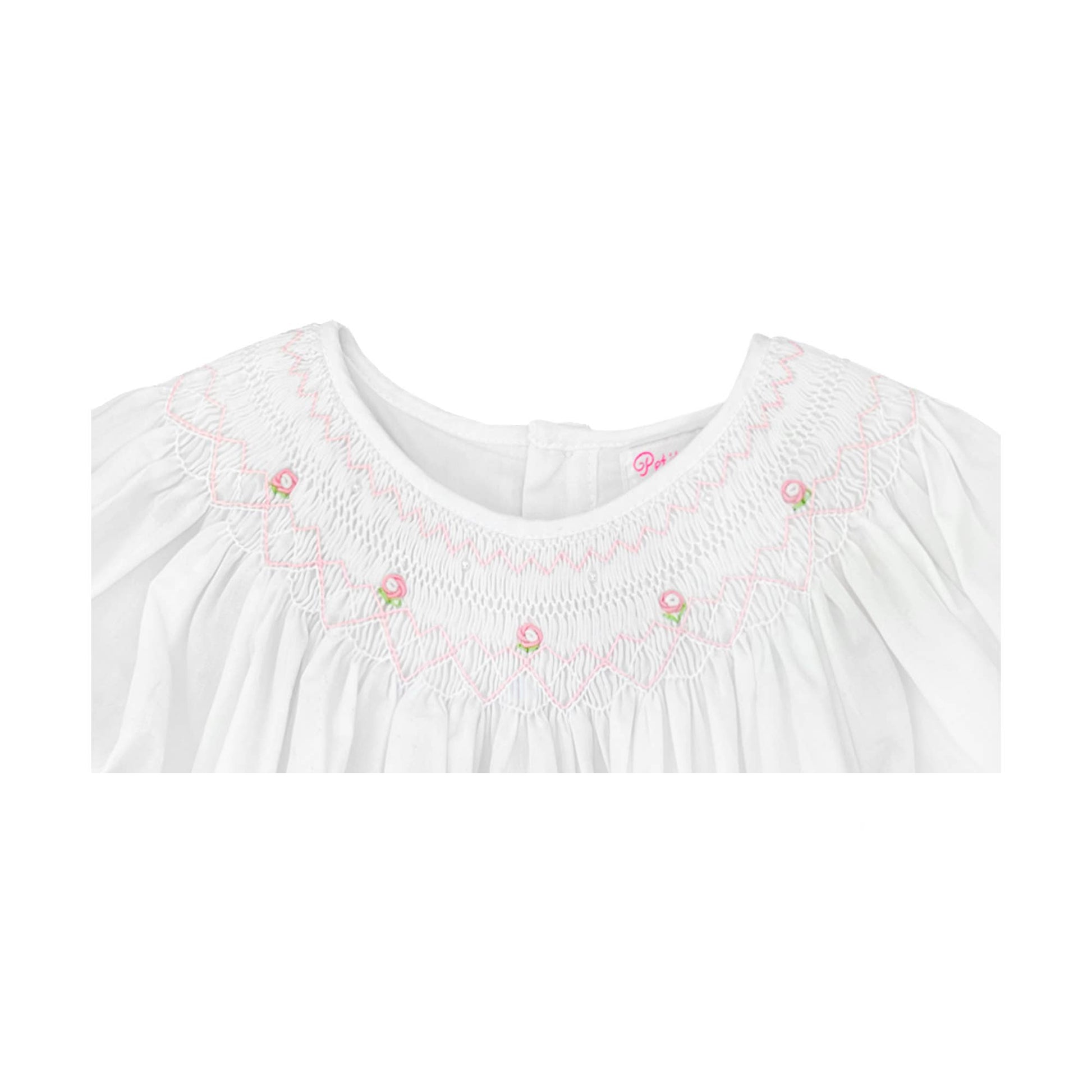 Neckline of White daygown with heart smocking and pearls