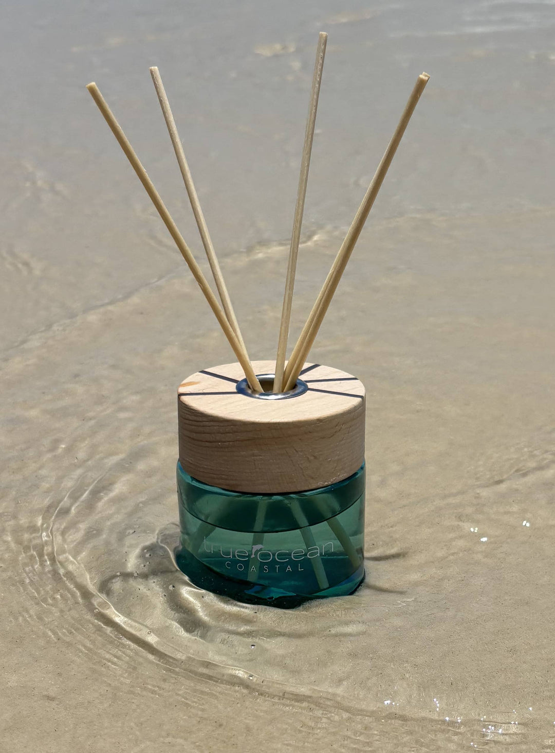 A True Ocean Reed Diffuser with four wooden reeds and a wooden cap. Available in 100ml and 200ml sizes.