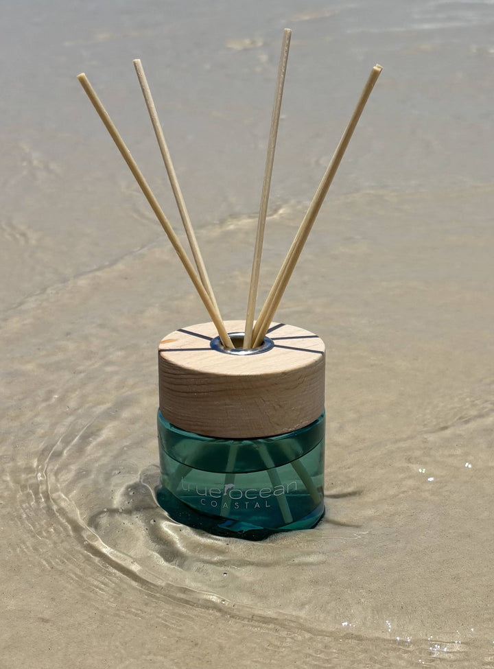 A True Ocean Reed Diffuser with four wooden reeds and a wooden cap. Available in 100ml and 200ml sizes.
