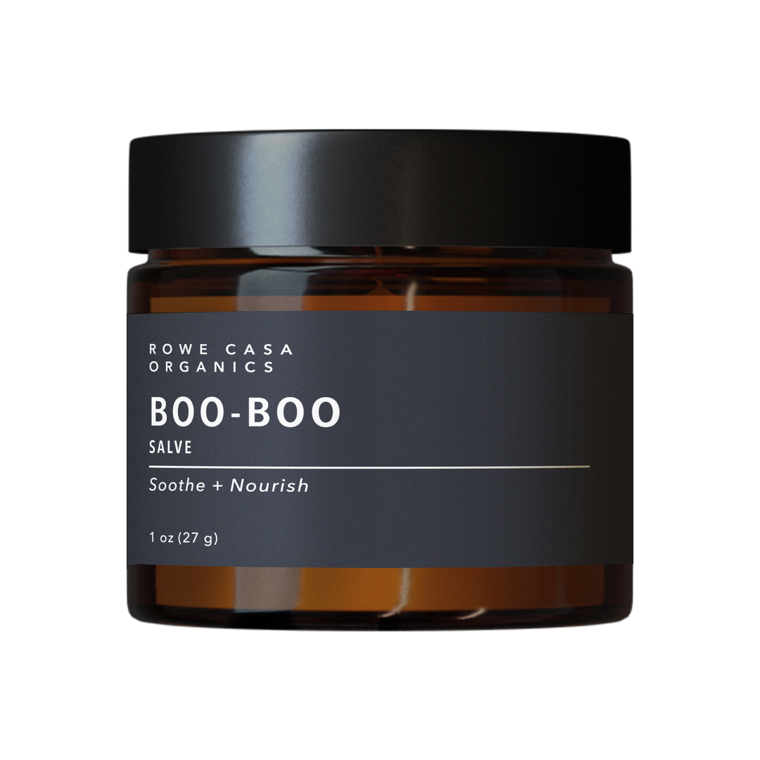 Amber jar with black lid labeled “Boo-Boo Salve | 1 oz.” Available in 1 oz size. Kid-safe ointment for bumps and scrapes.