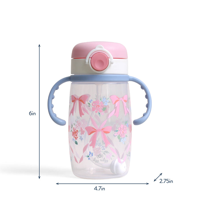 Clear, spill-proof sippy cup with pink lid, blue handles, floral and bow designs. Size: 6"x4.7"x2.75".
