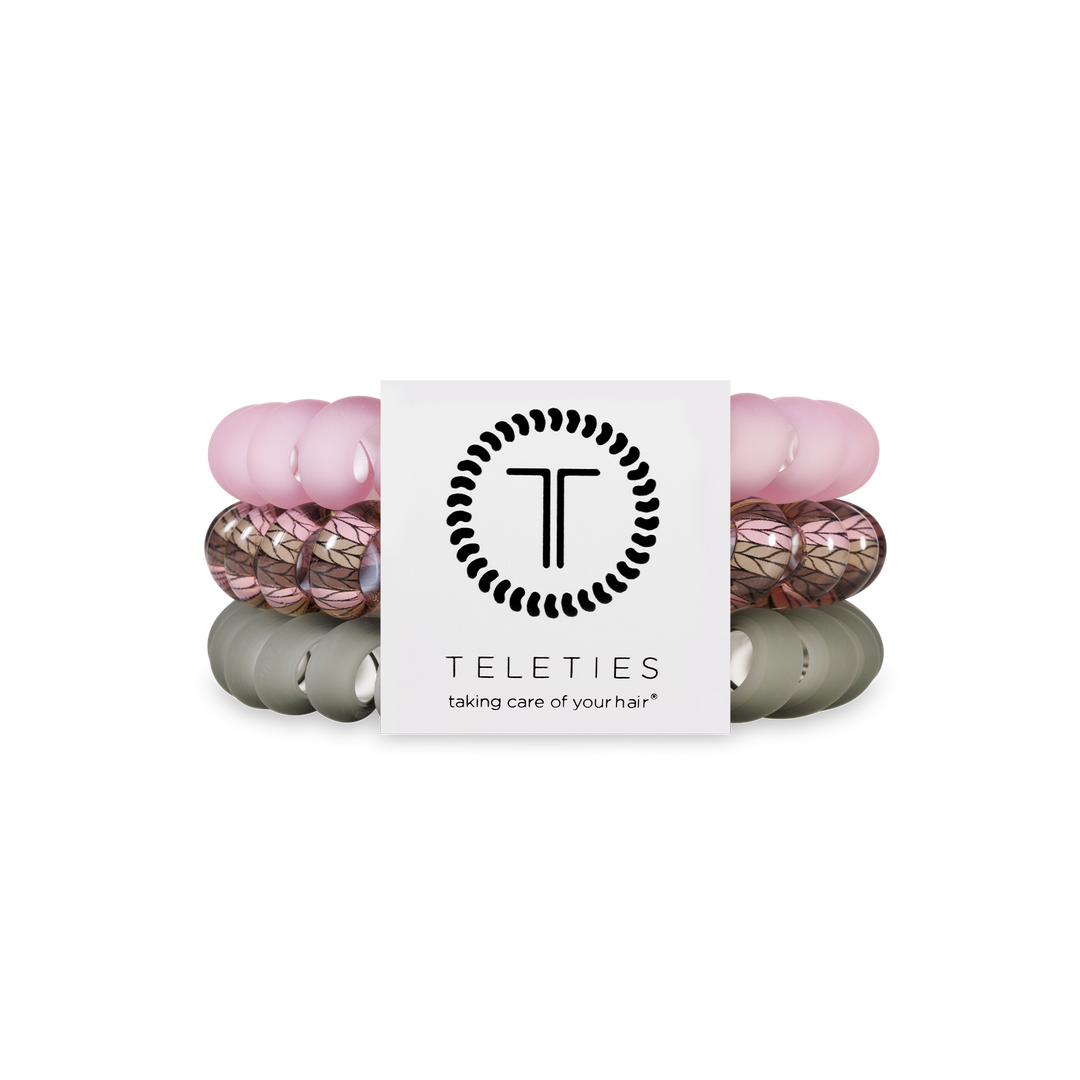 Three TELETIES Hair Ties in pink, leaf-patterned, and olive; available in small, medium, and large sizes.