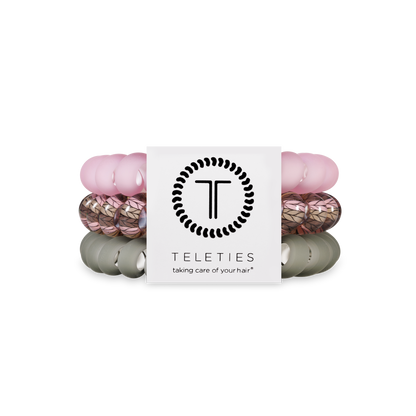 Three TELETIES Hair Ties in pink, leaf-patterned, and olive; available in small, medium, and large sizes.