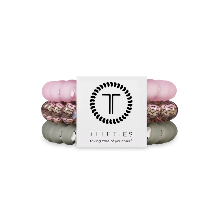 Three TELETIES Hair Ties in pink, leaf-patterned, and olive; available in small, medium, and large sizes.