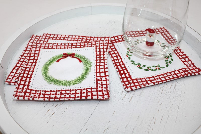 Two square embroidered Christmas wreath coasters with red plaid borders.