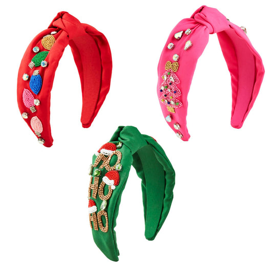 Three colorful Holiday Beaded Headbands: 
- Red headband with festive beaded decorations.
- Green headband featuring "HO HO HO" beaded text and holiday embellishments.
- Pink headband decorated with beaded charms and rhinestones. 
Sizes available: One size fits all.