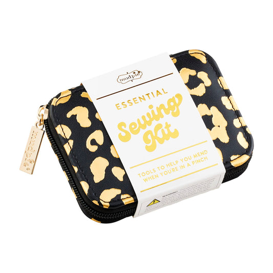 Compact Leopard Sewing Kit in a zipper case with a beige tag reading "Essential Sewing Kit" and "Tools to help you mend when you're in a pinch." Features a gold charm on the zipper pull, crafted from stylish faux leather. Available sizes: One Size.