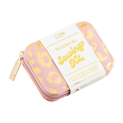 A small, pink faux leather Leopard Sewing Kit case with gold leopard print accents. Labeled tag reads "Essential Sewing Kit" and "Tools to help you mend when you're in a pinch." Features a zipper closure with a gold pull tab. Size: Small only.