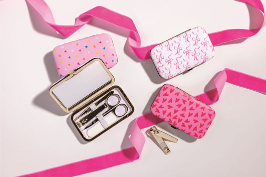 Three Essential Manicure Kits in pink heart and bow designs with ribbons, each containing scissors, clippers, tweezers, nail file. Sizes: S/M/L.