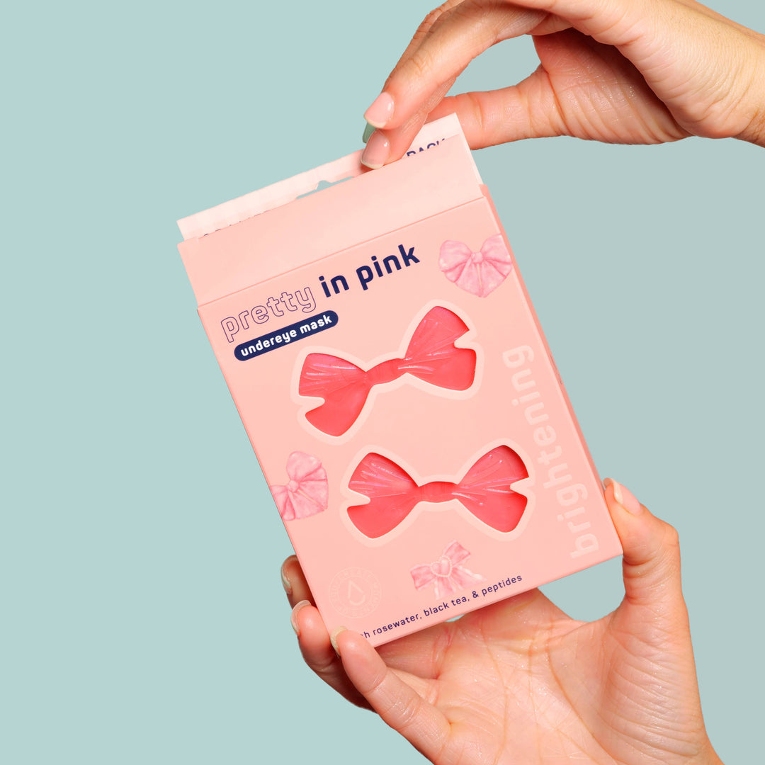 Pretty in Pink! Brightening Undereye Masks, Pack of 8. Bow-shaped, rosewater-infused masks visible through clear window.