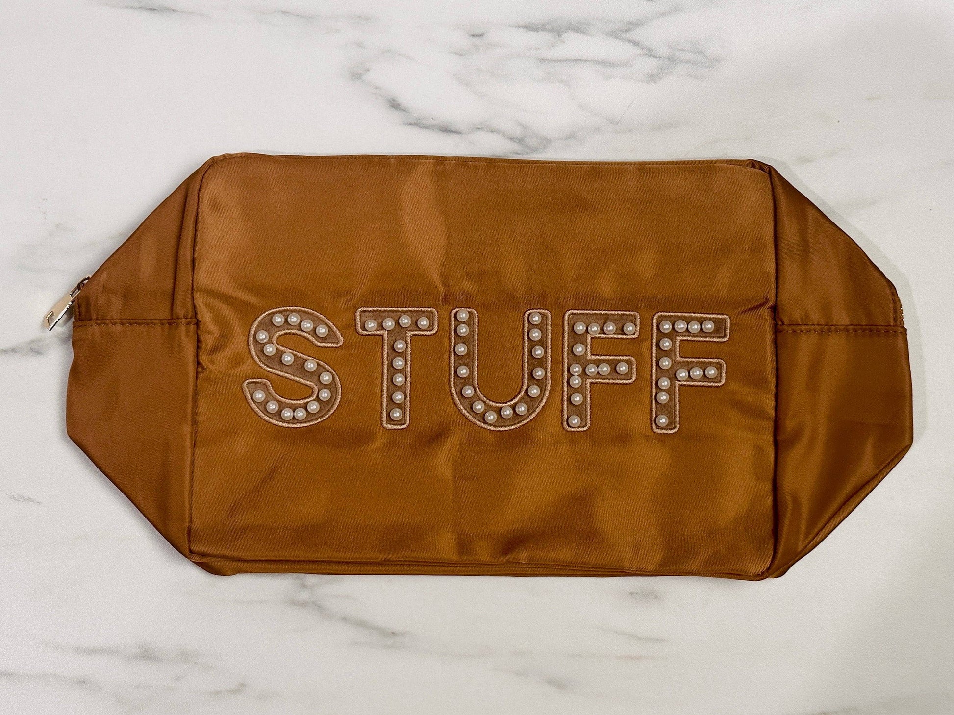 Stuff Nylon Bag Pouch - Cognac

- Sewn-on pearl varsity letter initials: "STUFF" 
- Bold stylized letters with white circles
- Shiny gold zipper 
- Sizes available: Extra Large