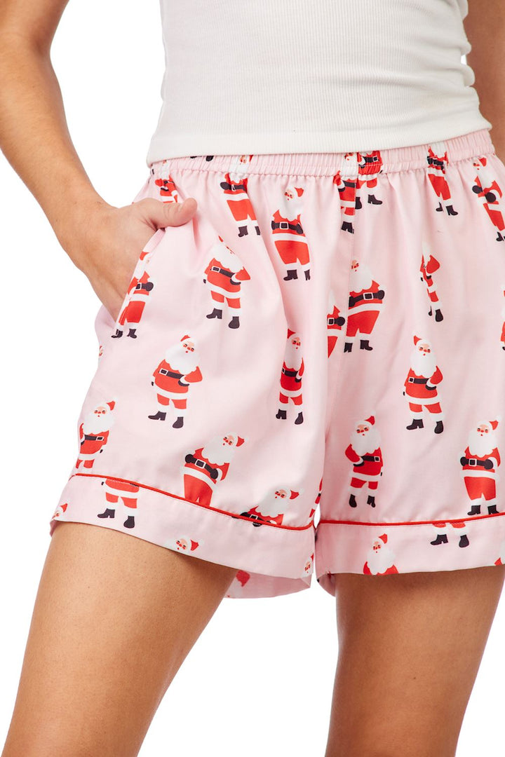 Pink Santa pajama shorts with a festive Santa Claus pattern and red piping trim. Available in multiple sizes.