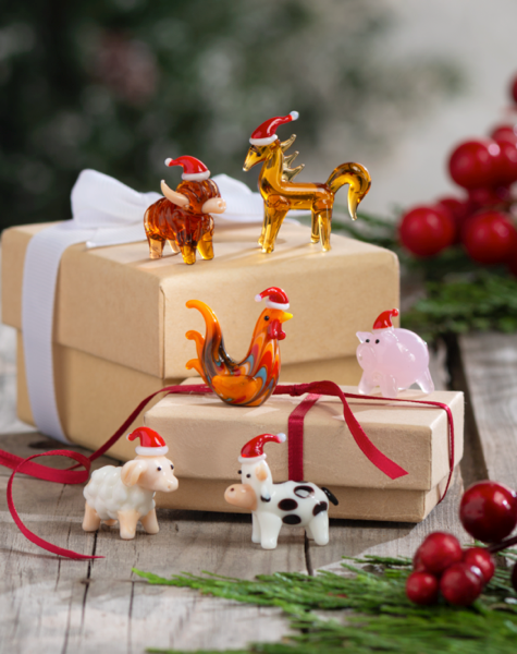 Miniature glass highland cow, horse, rooster, pig, sheep, and cow figures wearing Santa hats.