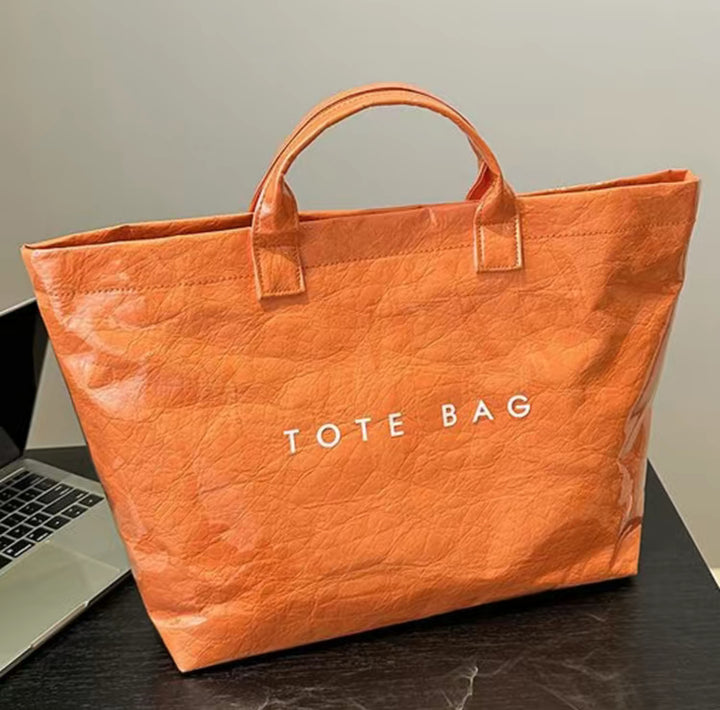Orange Vintage Tote Bag with two handles, bold white "TOTE BAG" print on front. Available in small, medium, and large sizes.