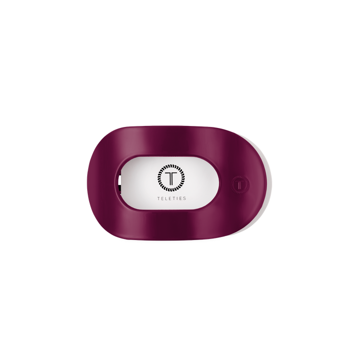 Maroon, oval-shaped plastic hair tie holder with open slot and TELETIES logo in black; available in multiple sizes.