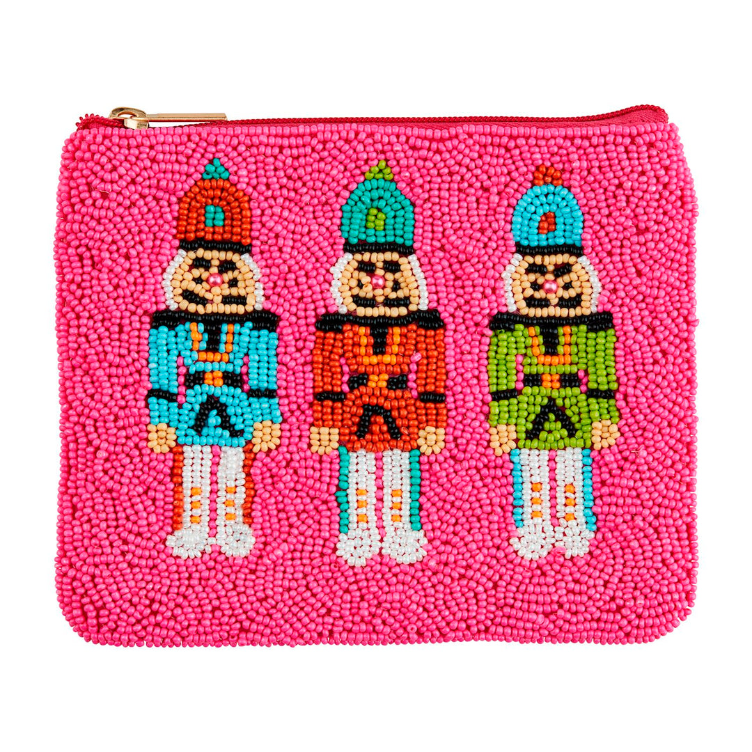 Pink zippered Holiday Beaded Case decorated with three beaded nutcracker figures in teal, orange, and green uniforms.