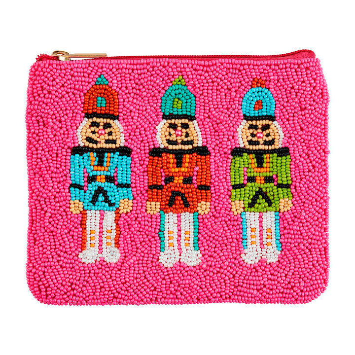 Pink zippered Holiday Beaded Case decorated with three beaded nutcracker figures in teal, orange, and green uniforms.