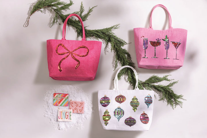 Three jute Holiday Sparkle Totes with bow, cocktail, or holiday ornament designs.