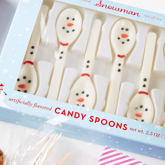 Snowman Set of 6 Edible Vanilla Flavor Candy Spoons. Small black eyes and orange noses shaped like snowmen. Light blue packaging with snowflakes. Net wt. 2.5 oz.