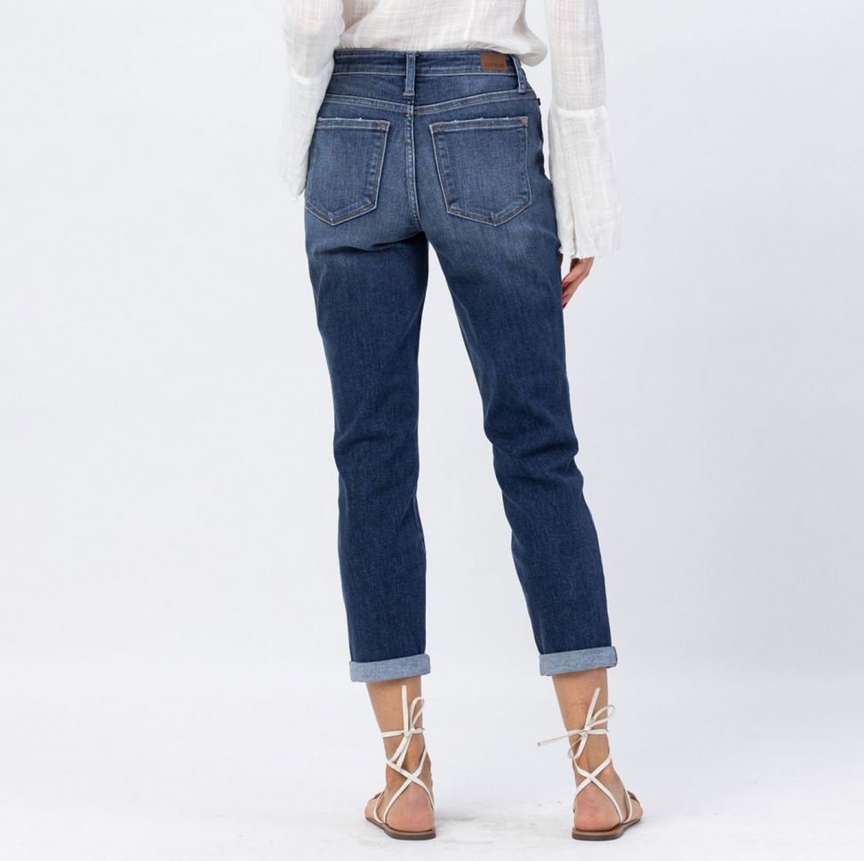 Judy Blue Midrise Cuffed Boyfriend Jeans. Sizes: 24-32. White long-sleeve blouse with billowy sleeves. Sizes: S-L. White flat sandals with ankle ties.