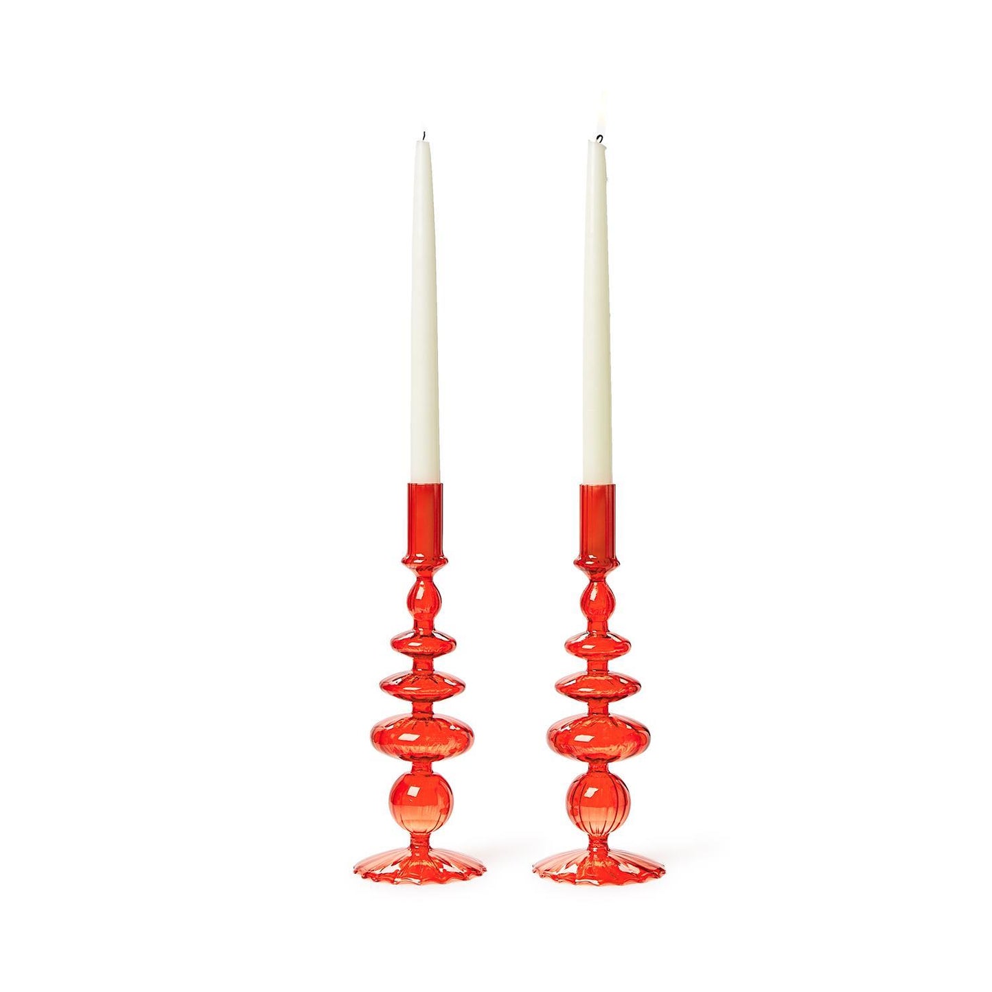 Two red glass candleholders with a wavy sculptural design. Each holds a tall white taper candle and has a glossy, reflective finish for vibrant holiday decor. Available size: standard taper candle height compatibility.