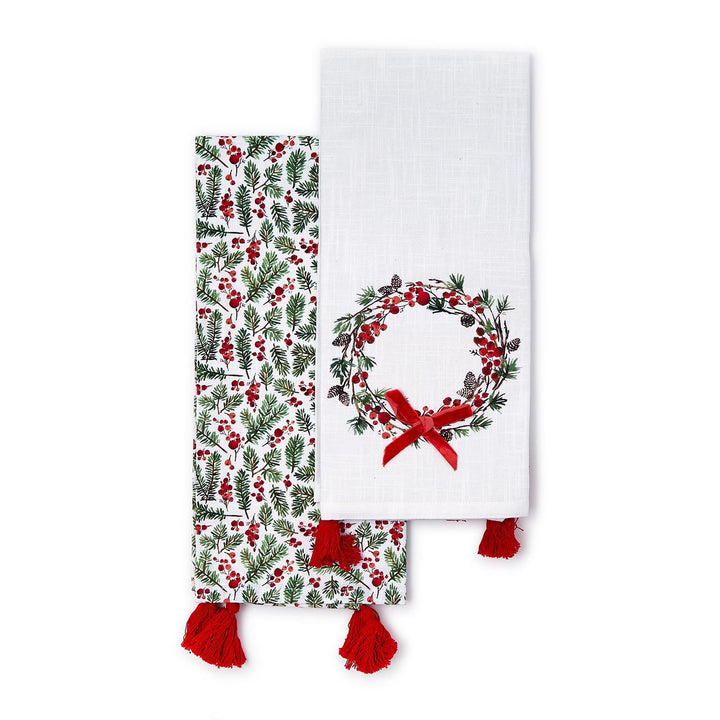 Merry Berry set of 2 dish towels featuring one with holly and pine pattern and one with a wreath and red velvet bow, both with red tassels.
