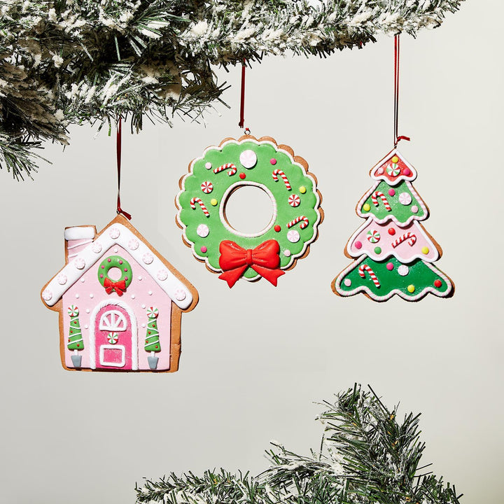 Three exquisite Gingerbread Hand-Crafted Ornaments: a pink gingerbread house, a green wreath with candy and red bow, and a green Christmas tree with red and white ornaments. Sizes: 4" each.