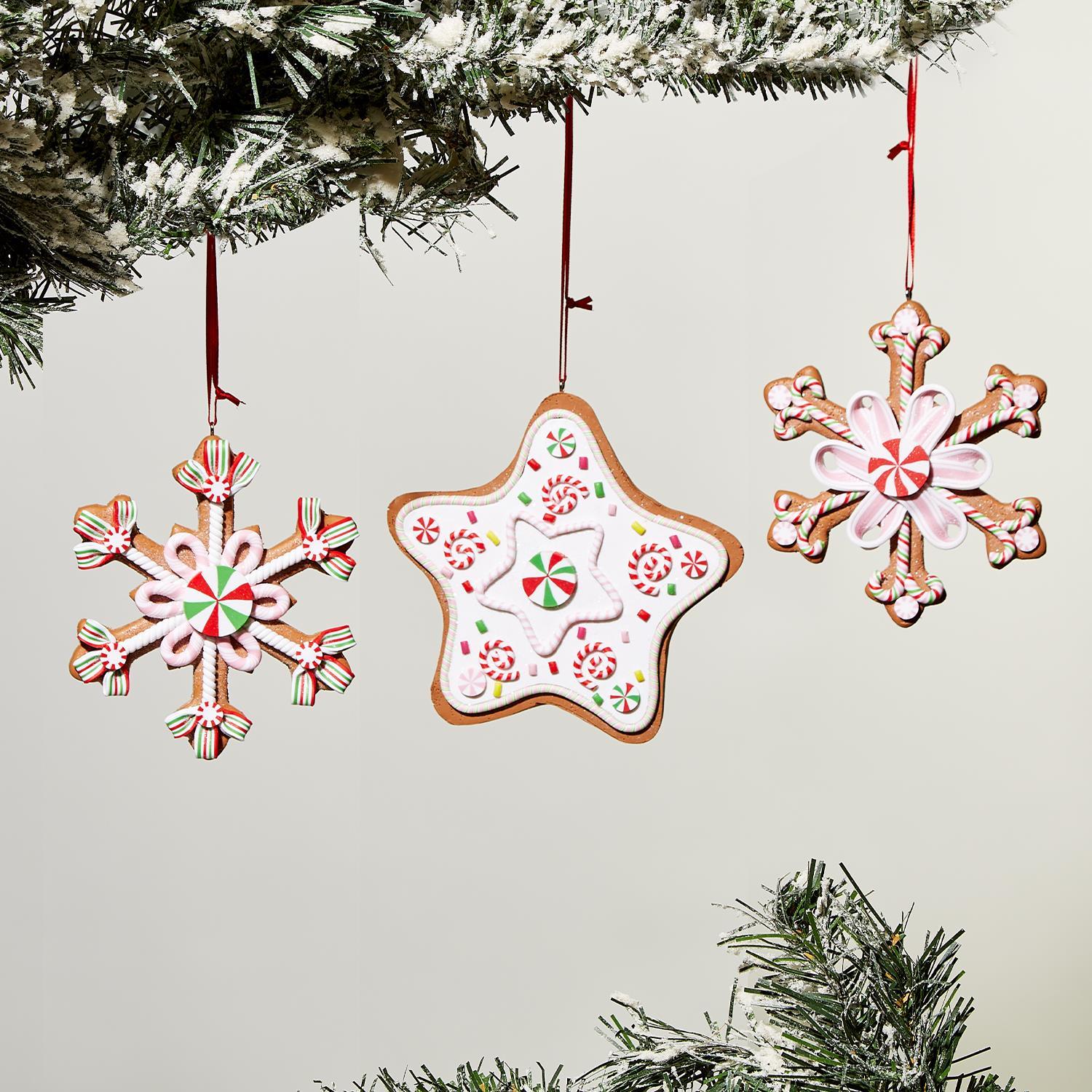 Three Gingerbread Hand-Crafted Ornaments, embellished with icing and candy; two snowflake shapes and one star in festive red, green, and white. Sizes: N/A.