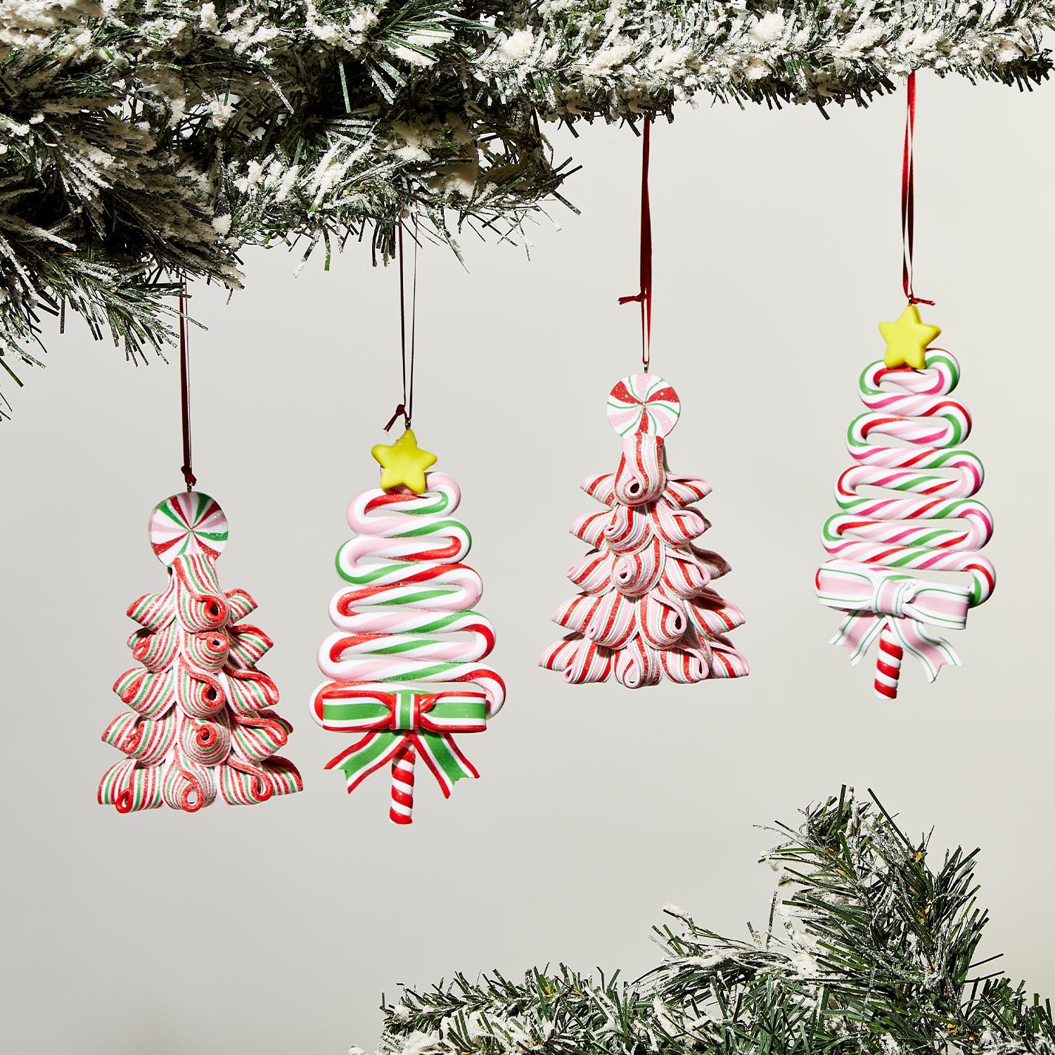 Four hand-crafted gingerbread ornaments shaped like festive trees. Features red, green, and white candy patterns with a yellow star and ribbon bows. Size: not specified.