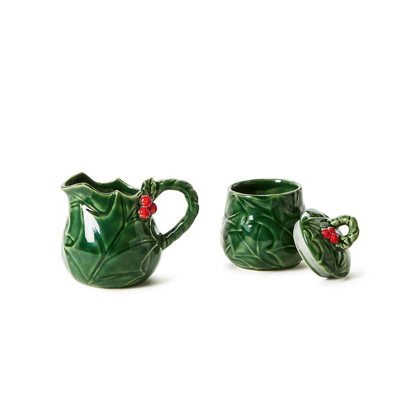 The Holiday Holly Creamer and Sugar Set is a stoneware collection featuring an embossed holly leaf design with red berry accents. Includes a small pitcher with handle and a lidded sugar bowl. Sizes available: One size set.