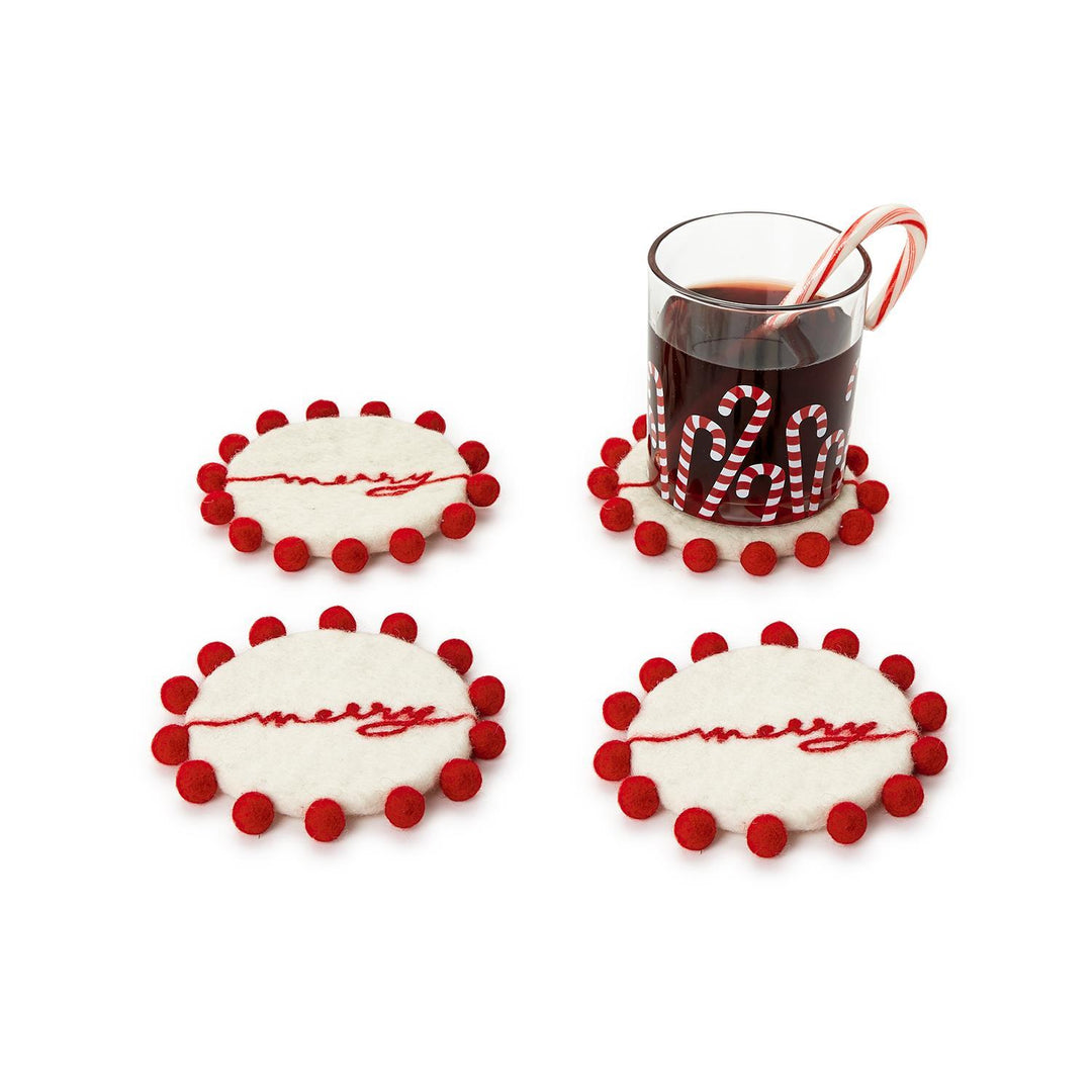 Set of 4 hand-crafted round felt coasters with red pom-pom edges and embroidered red “merry” script.