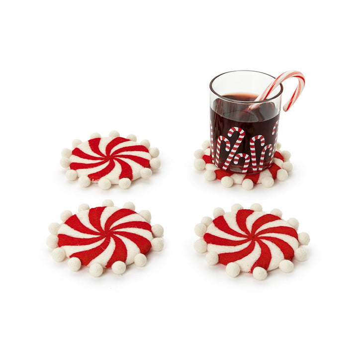 Set of 4 hand-crafted felt coasters with pom-poms featuring a red and white peppermint swirl pattern and white trim.