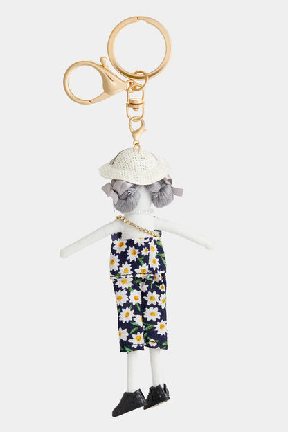 Darling Divas Bag Charm + Key Fob: gray-haired doll, white hat, floral jumpsuit, gold keyring & clasp. Sizes: S/M/L.