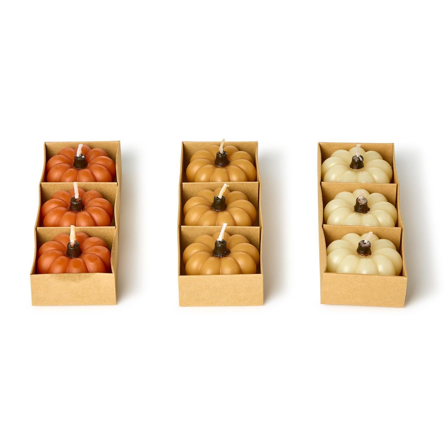 Set of six mini pumpkin candles in orange, tan, and cream. Gift boxed. Sizes not specified.