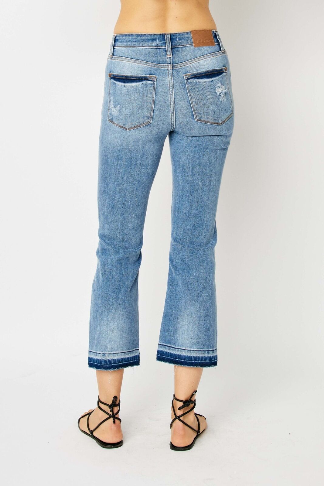 Judy Blue Mid Rise Release Hem Cropped Bootcut Jeans, light blue, frayed hems, minor distressing. Sizes: 0-24.