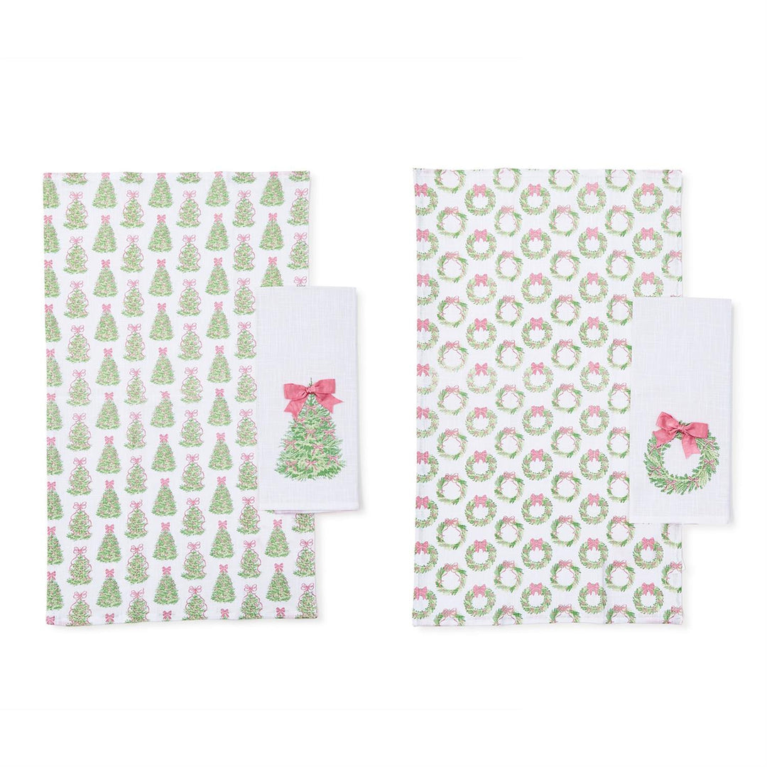 Two Bow-tiful Set of 2 Dish Towels with Satin Bow Accent in pastel pink, featuring a repeating print of Christmas trees, wreaths, and an embroidered motif.