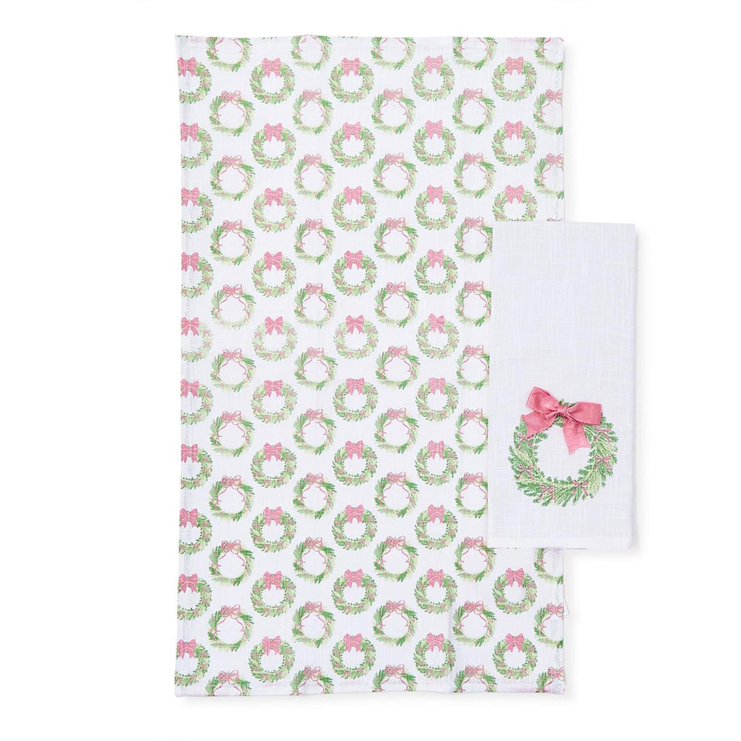 Set of 2 Bow-tiful dish towels: one with a green wreath and pink bow print, one white with an embroidered wreath and a pink satin bow.