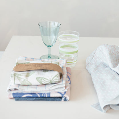 Stack of folded patterned kitchen towels, featuring a Printed Microfiber Tea Towel. Available sizes: 16"x24", 18"x28".