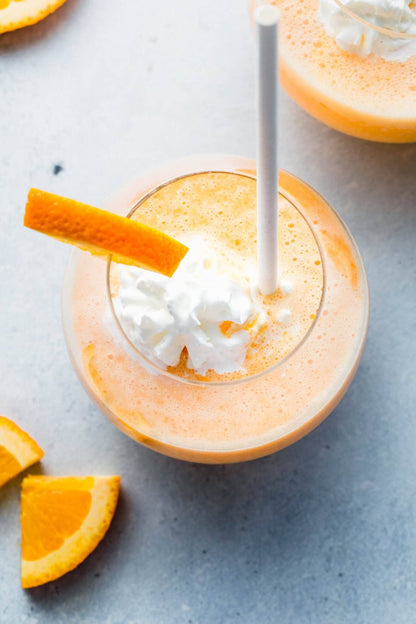 Creamy orange smoothie in a glass with whipped cream, orange slice, and straw. Available in 12oz and 16oz sizes.