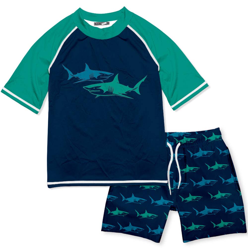 Kids Blue Shark Rashguard Set: blue rash guard with two shark graphics, matching trunks with shark print, white drawstring. Sizes XS-XL.