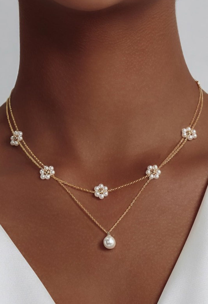 18K non-tarnish stainless steel chain necklace set with gold-plated pearl flower charms and a dangling pearl pendant. Sizes: S, M, L.